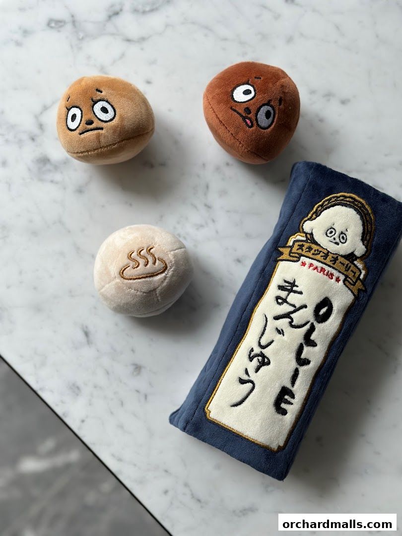 Plush toys with cute faces and Japanese text on a marble surface.