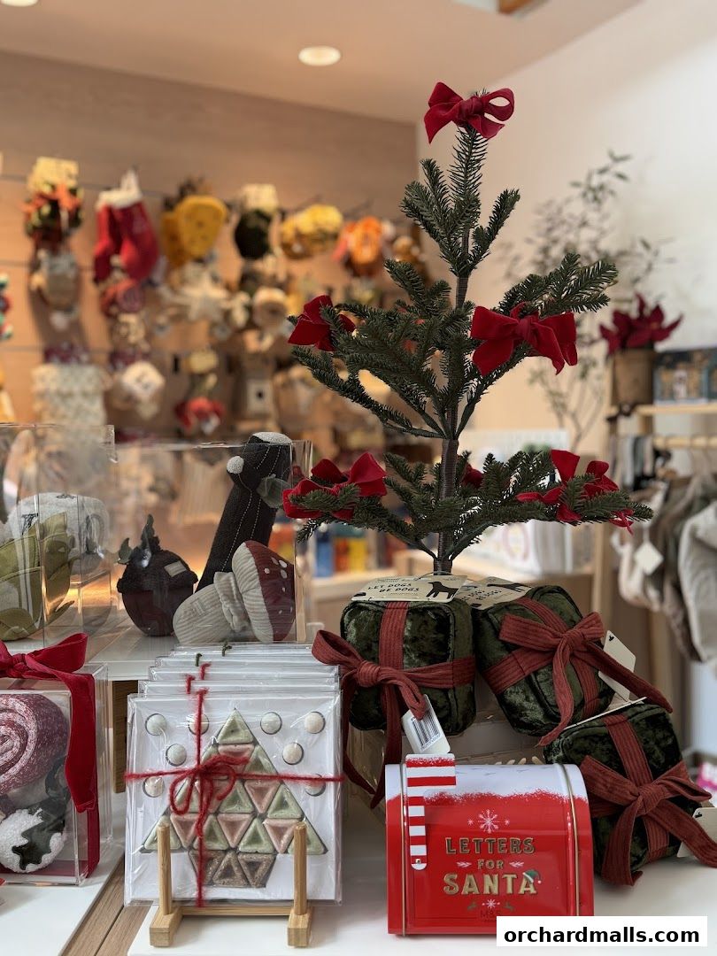 A festive display of Christmas-themed gifts and decorations, including a mini tree and 'Letters for Santa' mailbox.