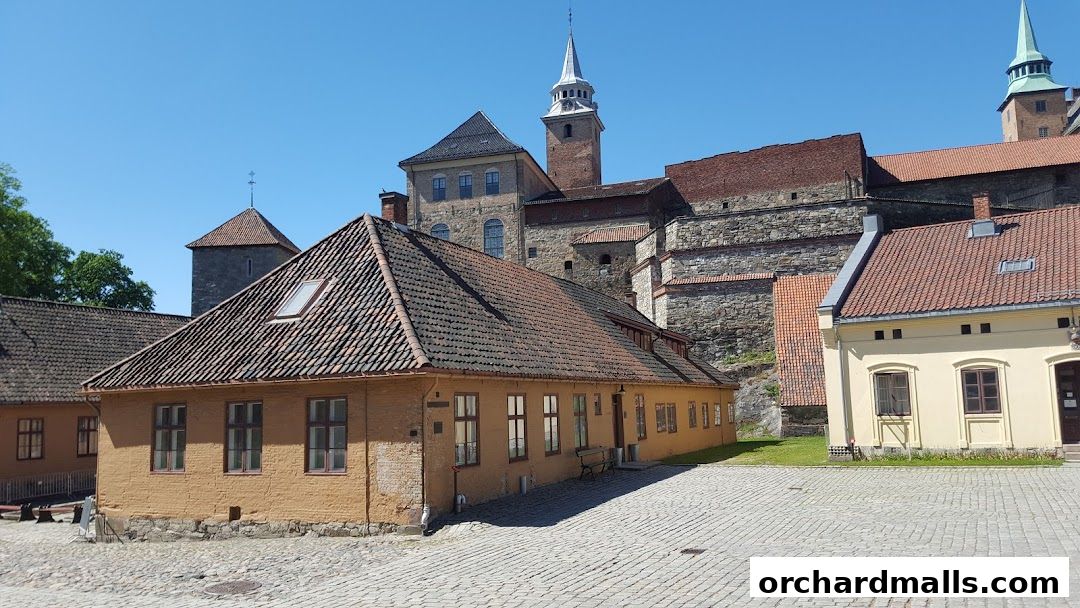 Historic buildings with tiled roofs and stone walls under a clear blue sky.