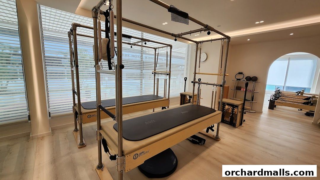 Interior of a modern Pilates studio with reformers and equipment.