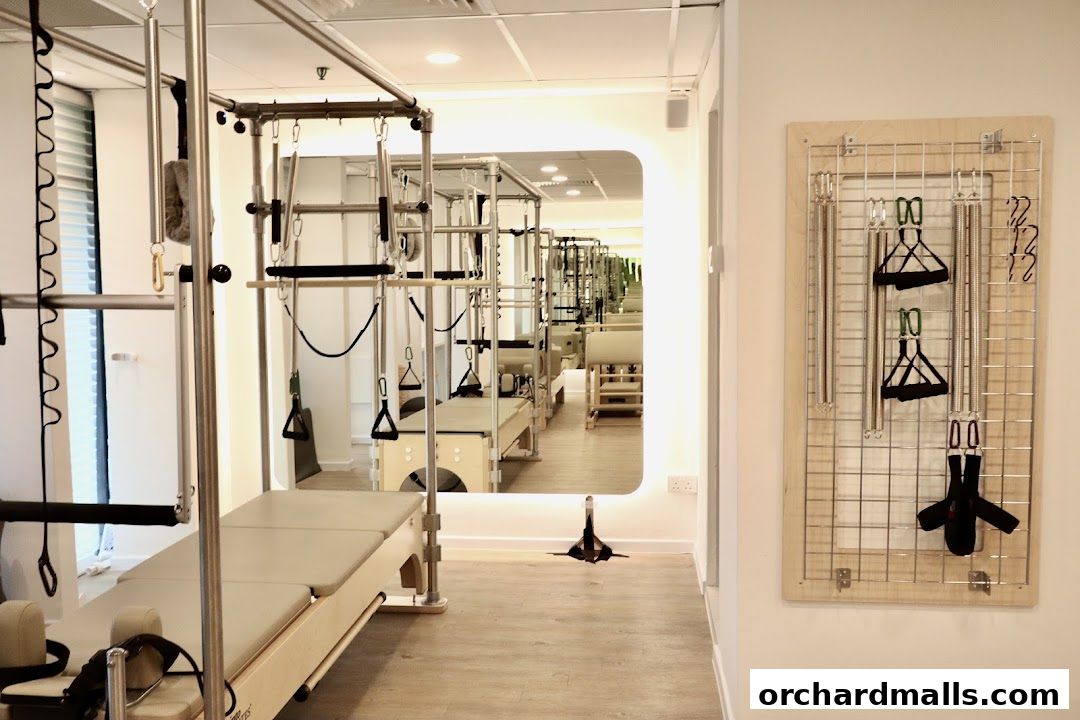 Interior of a modern Pilates studio with reformers and equipment.