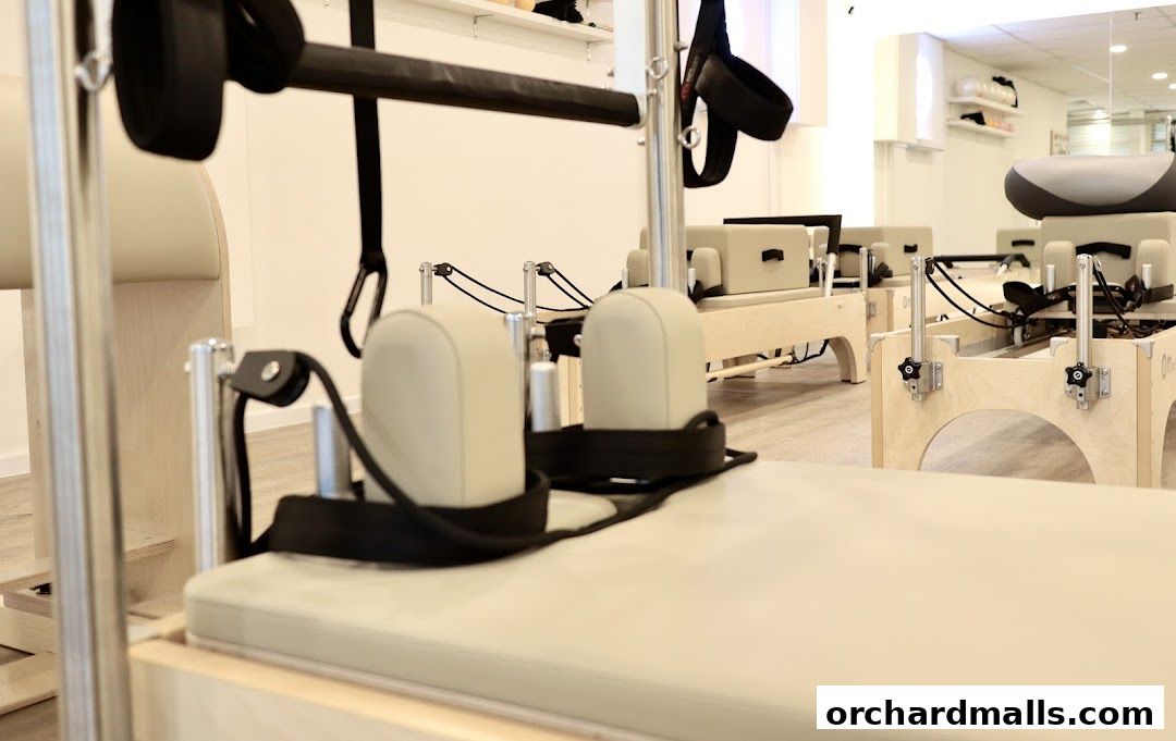 Interior shot of a Pilates studio with reformers and equipment.