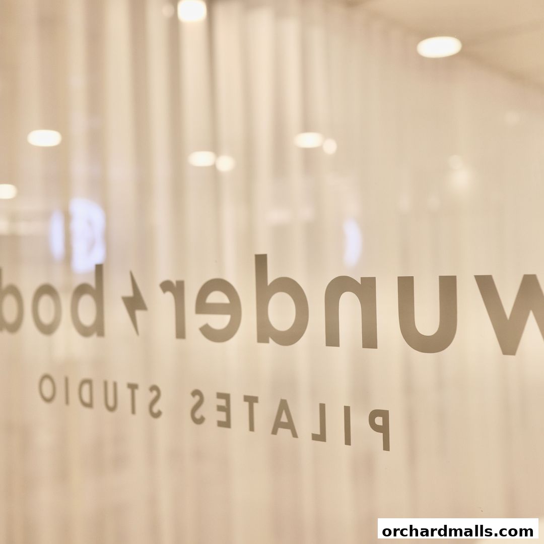 Reflection of 'Wunderbody Pilates Studio' logo on a glass door.
