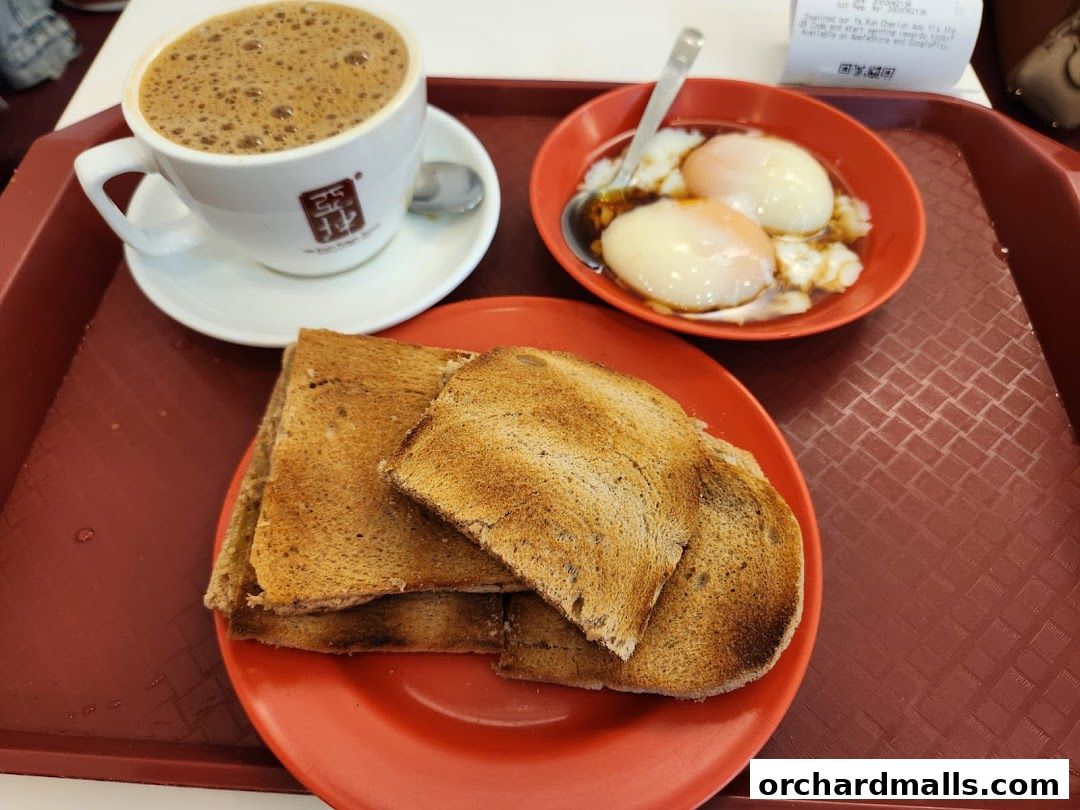 A tray with a cup of coffee, soft-boiled eggs, and toast from Ya Kun Kaya Toast.