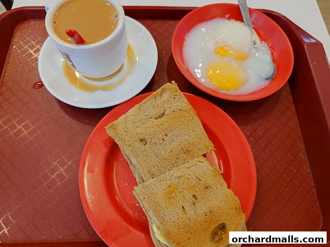 A tray with a cup of tea, soft-boiled eggs, and kaya toast.