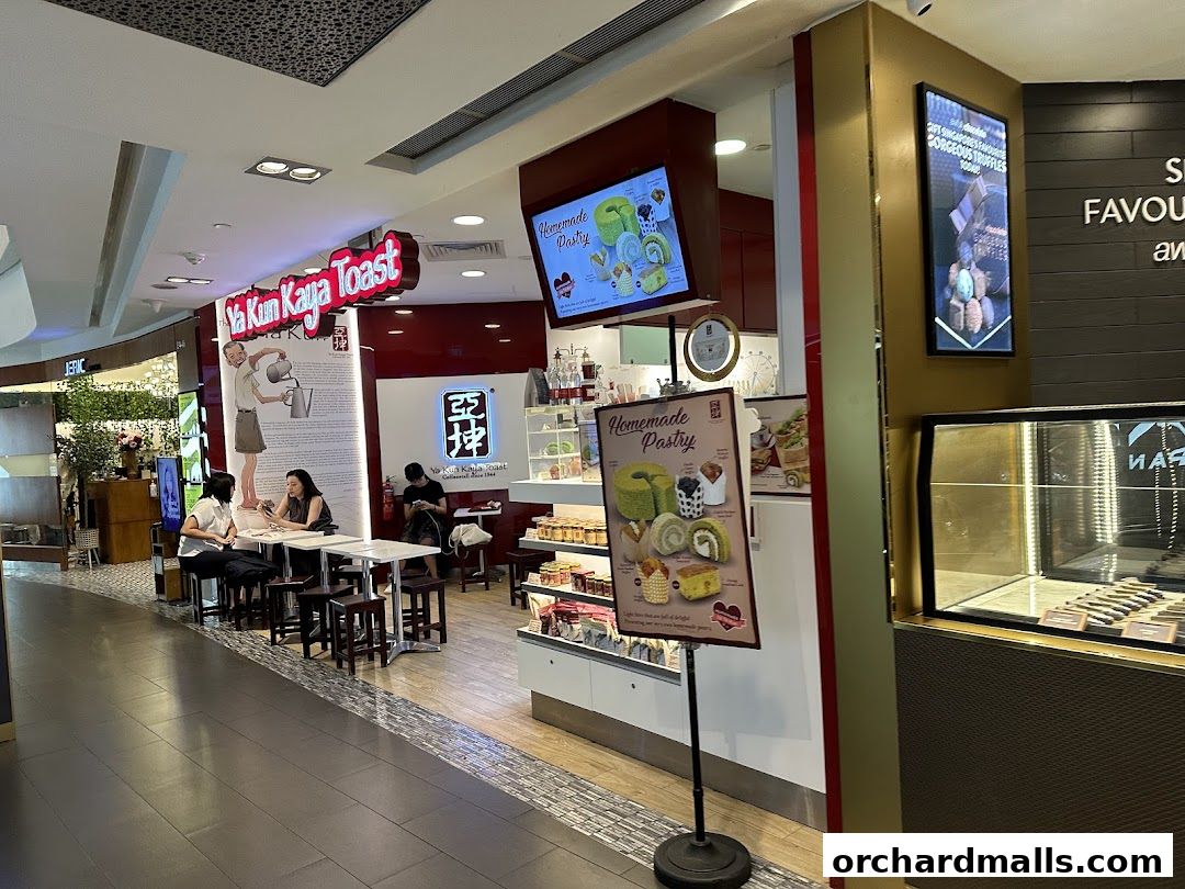 Interior view of Ya Kun Kaya Toast with customers and displayed pastries.
