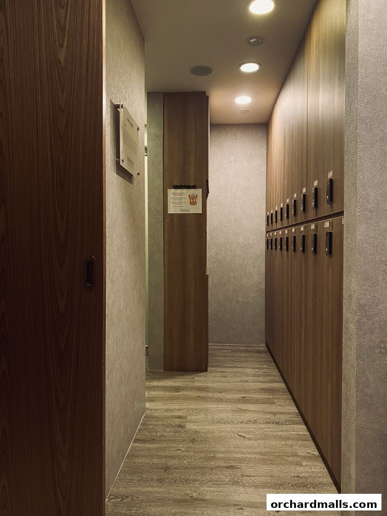 A hallway with wooden lockers and a sign that says 'UNIFORMS'.