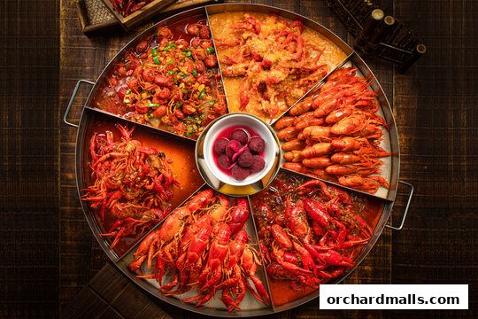 A large platter of assorted spicy crawfish dishes and pickled plums.
