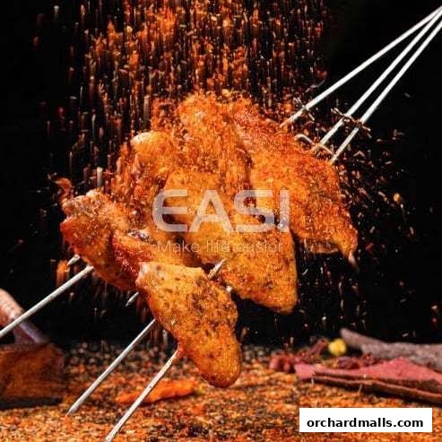 Spicy grilled chicken wings being seasoned with spices, presented on skewers.