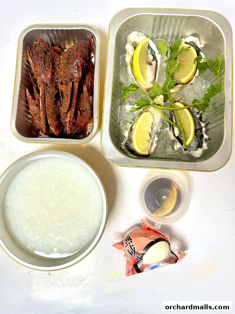 A spread of delicious food including oysters, grilled meat, and congee.