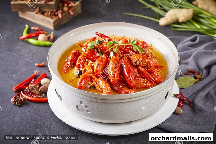 A steaming bowl of spicy crawfish with chili peppers and spices.