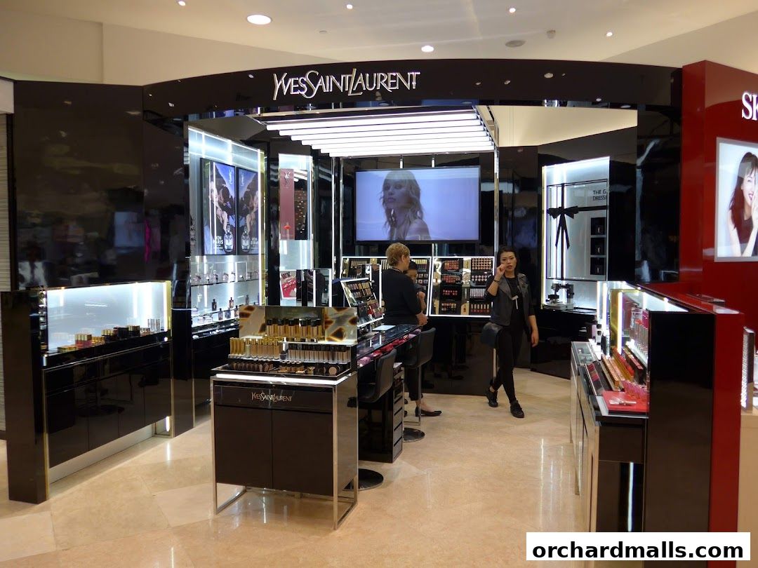 Interior of a YSL Yves Saint Laurent Beauté shop with makeup displays and staff.