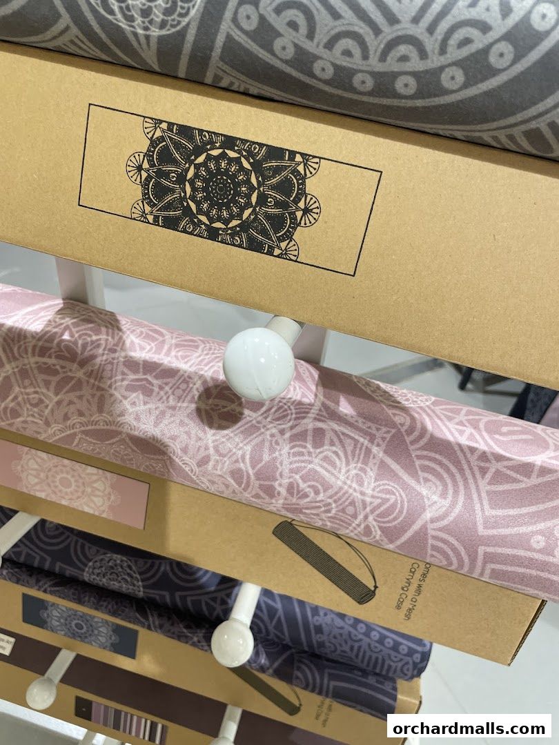 Rolled yoga mats with intricate mandala patterns displayed on shelves.