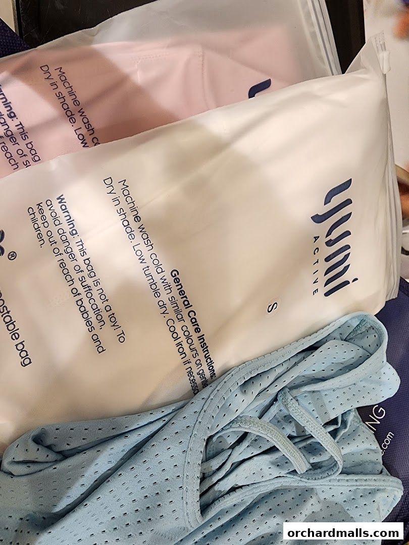 Packaged activewear in pink and white, with a blue garment peeking out.
