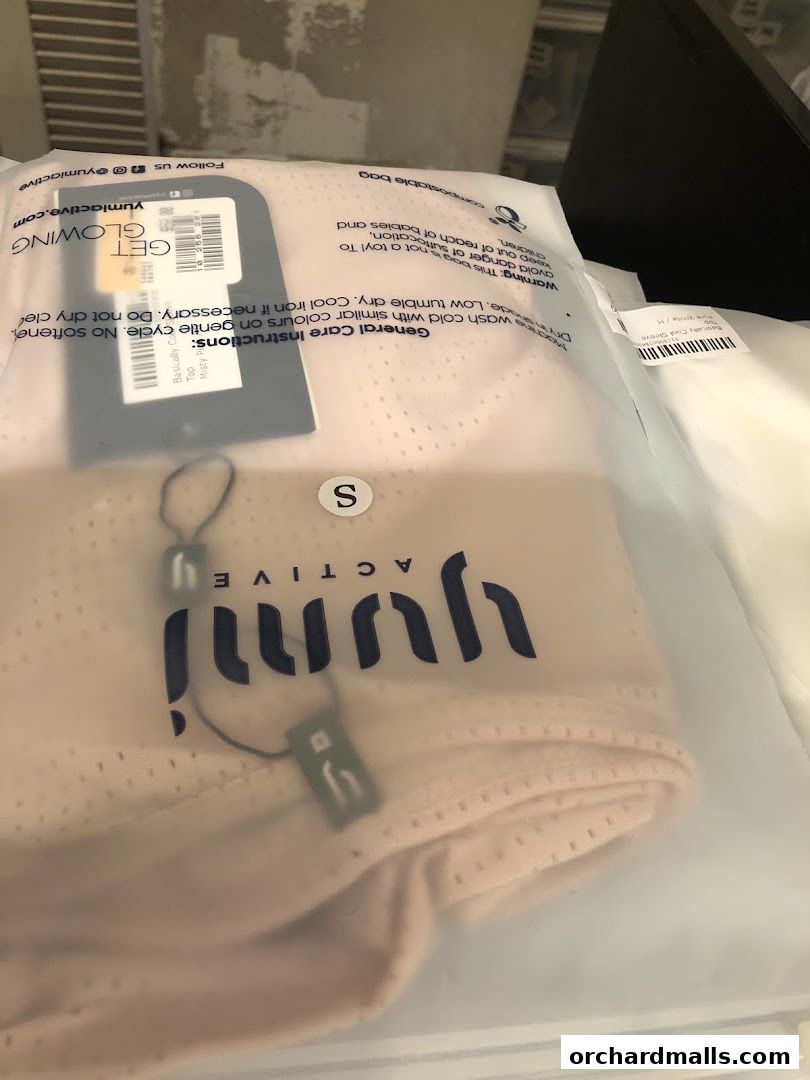 Packaged activewear from Yumi Active, featuring a pink top and a white sleeve top.