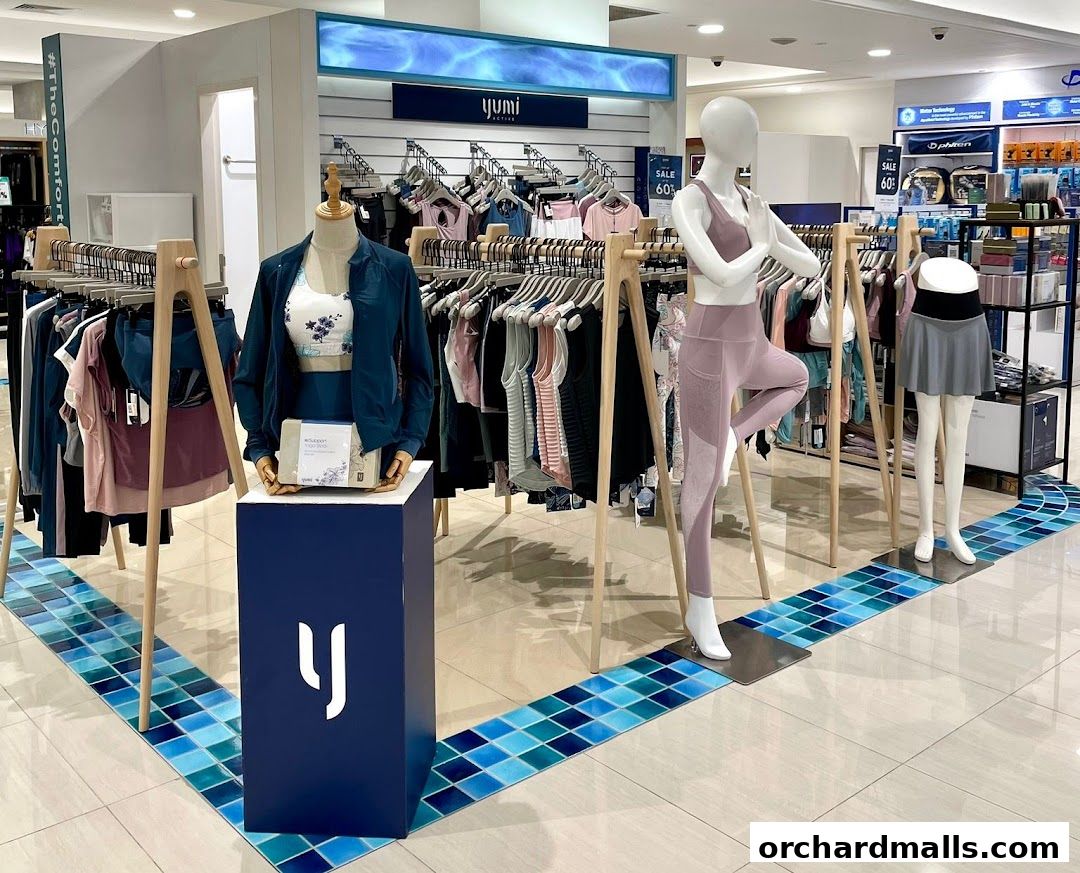 Yumi Active store display featuring mannequins in activewear and racks of clothing.