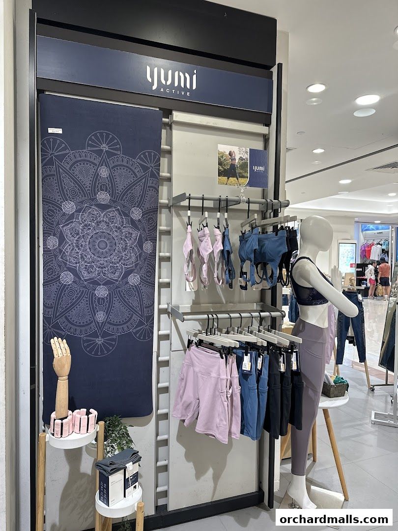 Yumi Active store display featuring yoga mats, sports bras, shorts, and leggings.