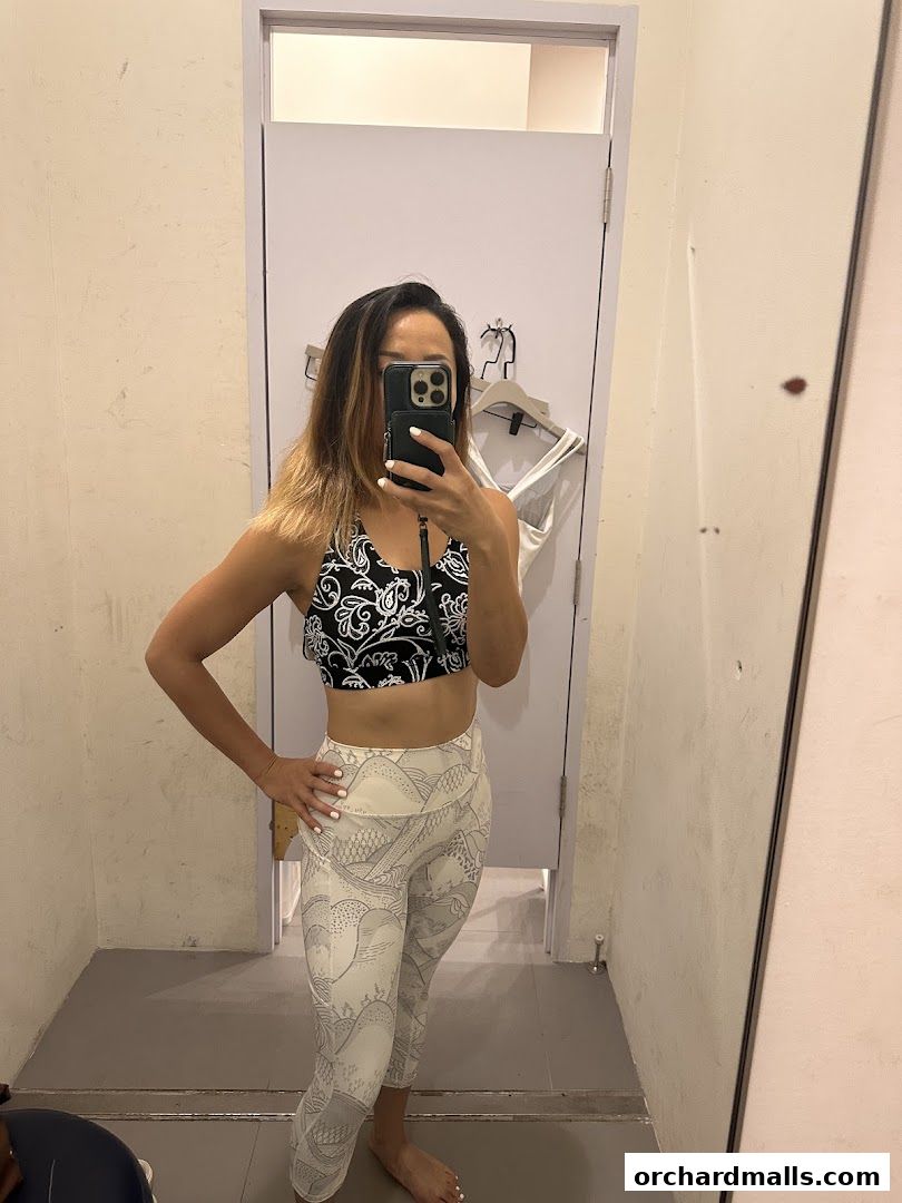 Woman trying on patterned activewear in a fitting room.