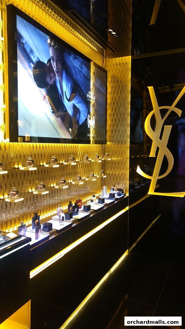 Luxurious Yves Saint Laurent Beauté store interior with illuminated perfume displays and prominent logo.