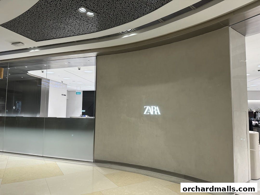 The Zara store entrance with its illuminated logo on a textured wall.