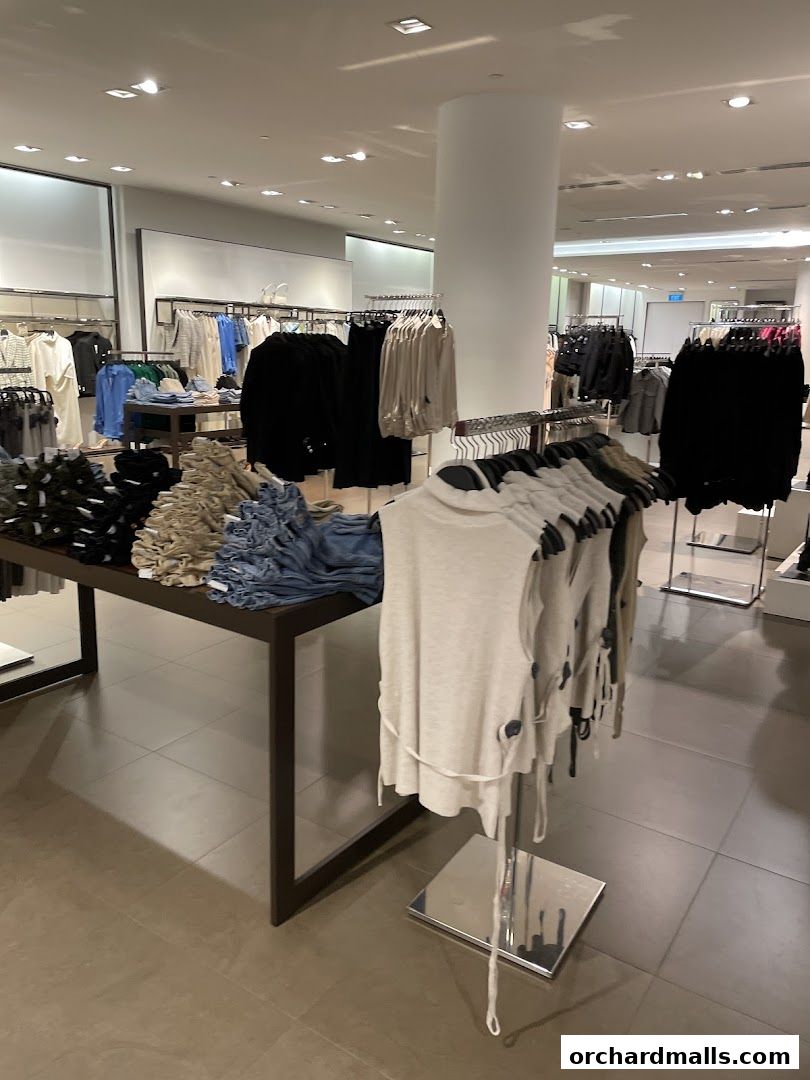 Interior view of a Zara clothing store showcasing a variety of apparel on racks and tables.