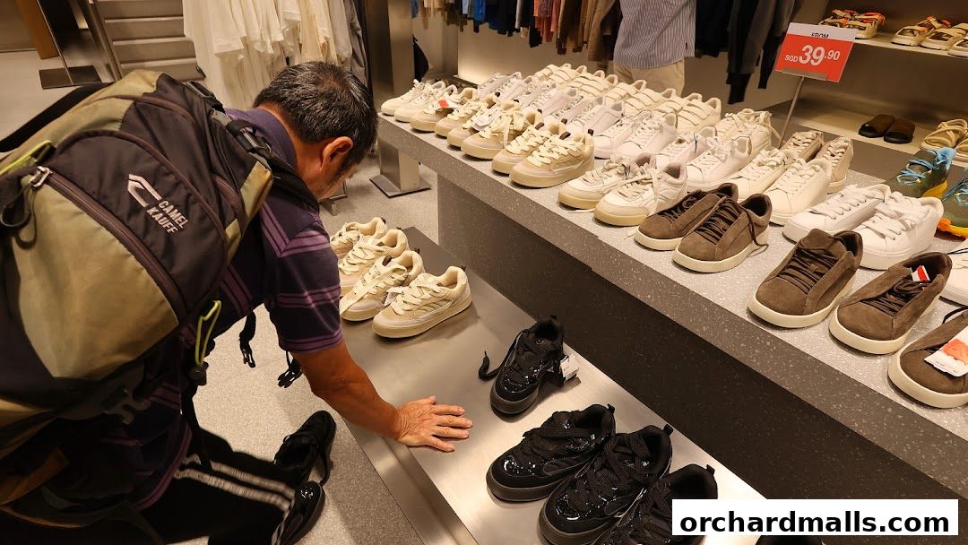 A man examines a display of stylish sneakers in a retail store.
