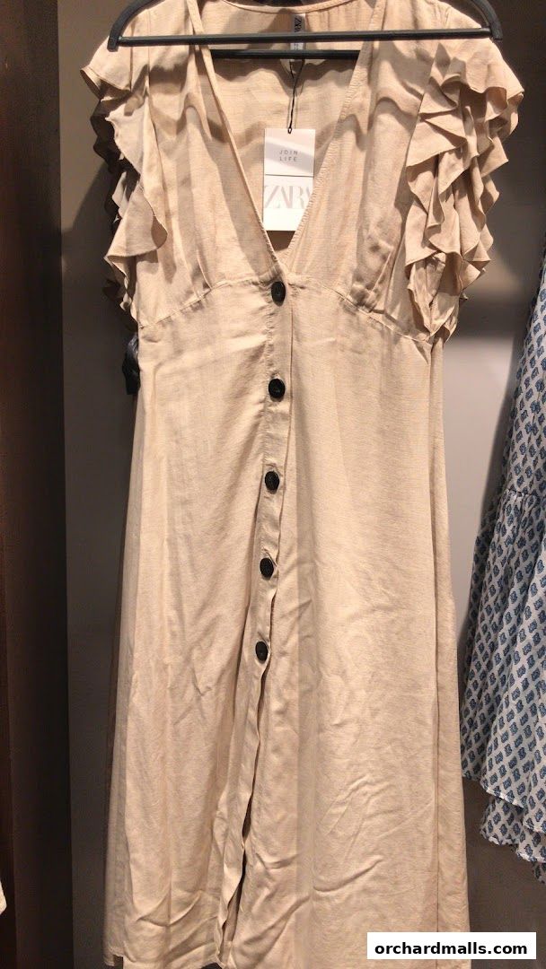 A beige linen dress with ruffled sleeves and button detailing from Zara.