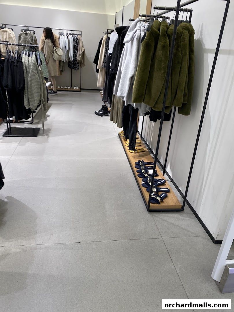 Interior view of a Zara clothing store with racks of apparel and shoes on display.