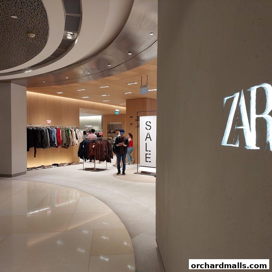 Interior view of a Zara store with clothing racks and a prominent 'SALE' sign.