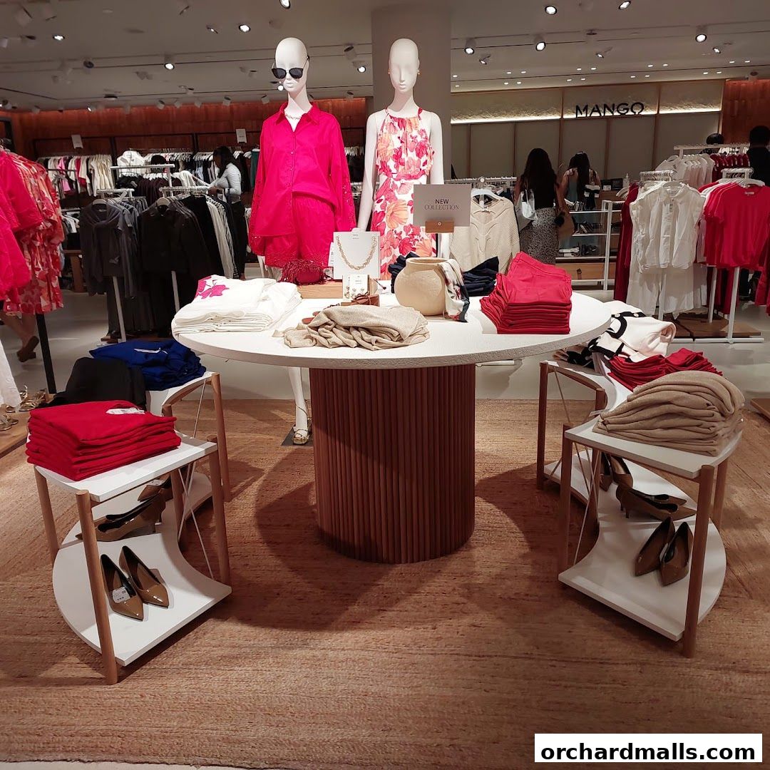 Mannequins display new collection clothing in a Zara store with folded apparel and shoes.