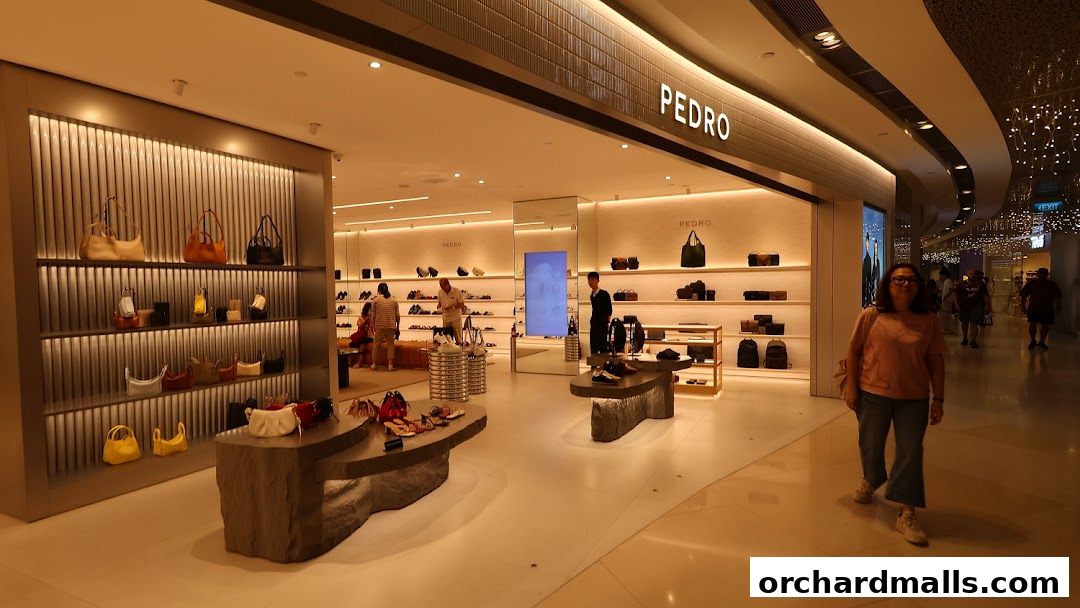 Interior view of a modern Pedro store showcasing handbags and shoes with customers browsing.
