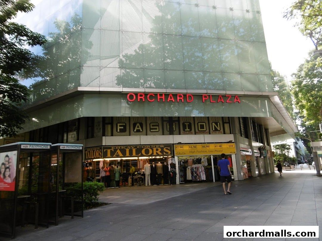 Exterior view of Orchard Plaza featuring fashion stores and tailors with price displays.