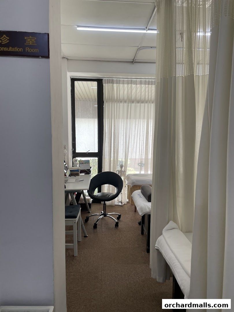 Interior view of a consultation room with treatment beds and a desk.