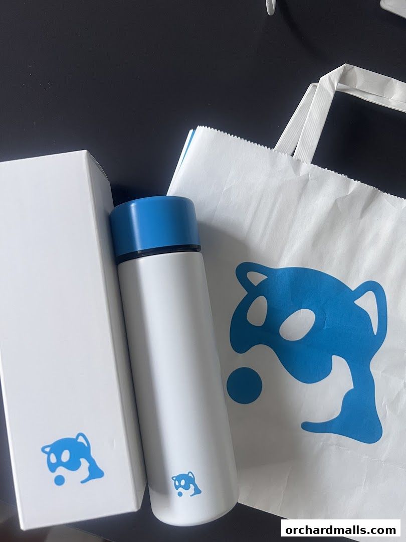 A white thermal flask with a blue lid, a white box, and a white shopping bag with a blue logo.