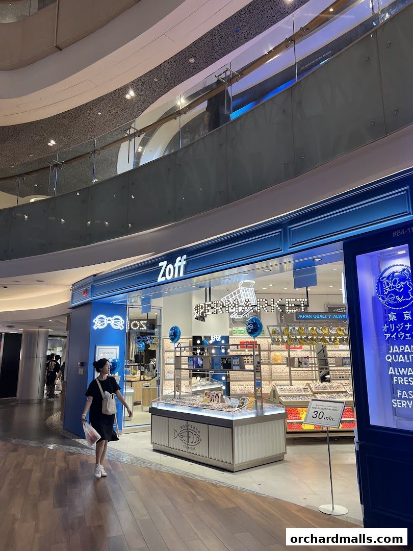 A woman walks past the Zoff eyewear store, showcasing a wide selection of glasses.