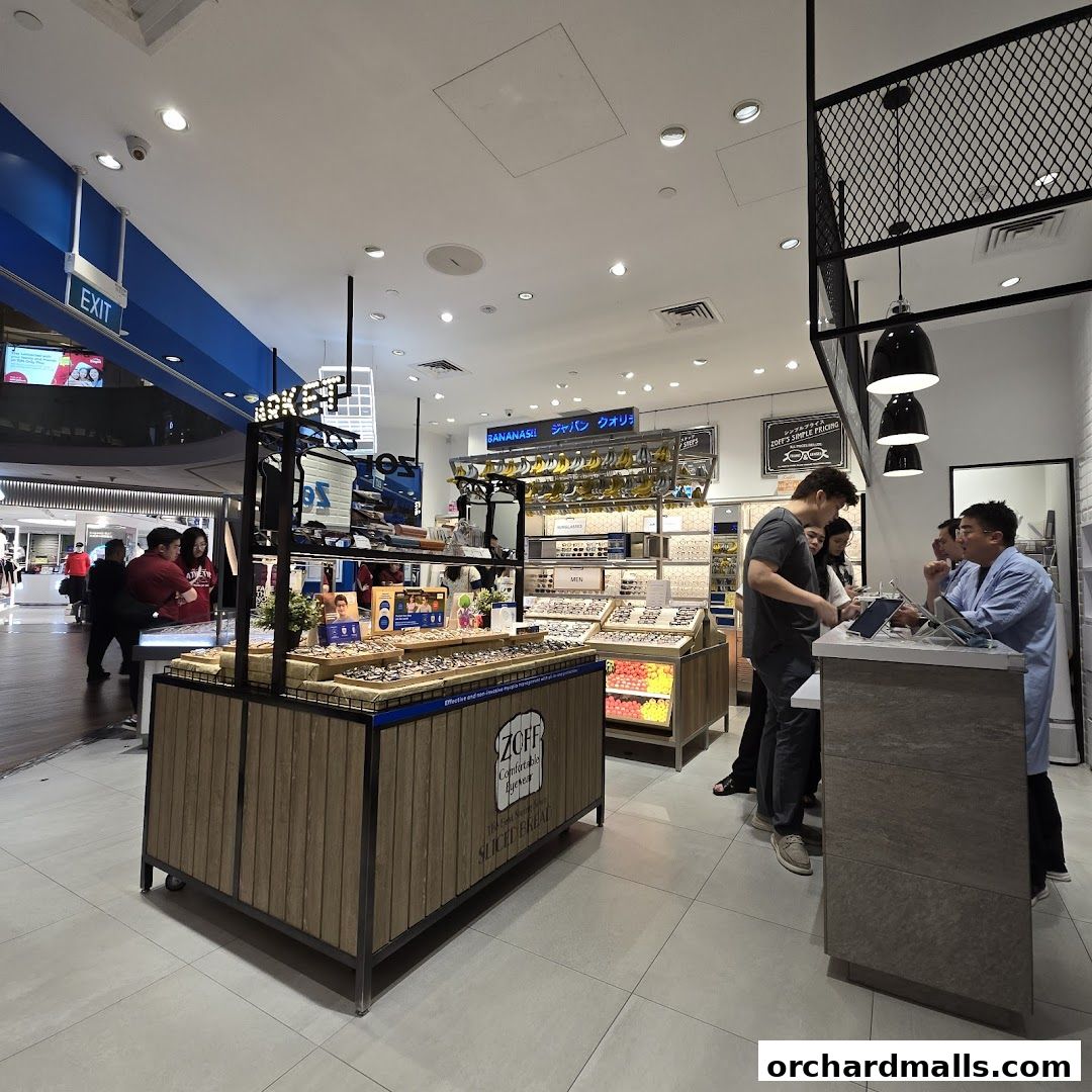 Interior of a Zoff eyewear store with displays of glasses and customers being served.